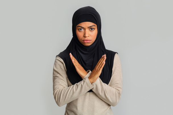 Black muslim woman making denial gesture, keeps arms crossed, rejecting something - Photo, Image