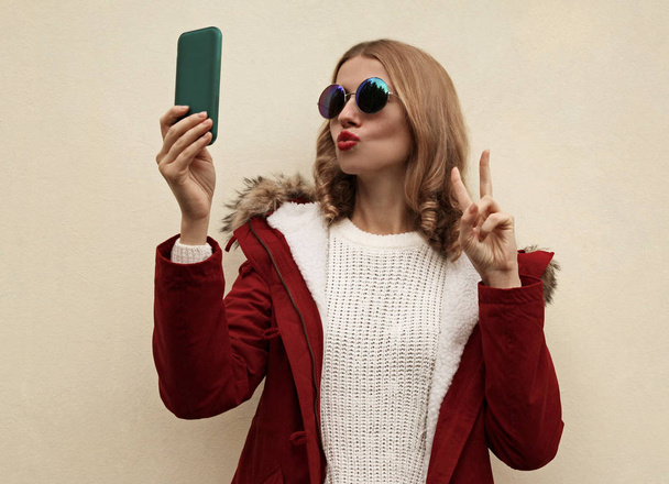 cool young woman blowing red lips taking selfie picture by smart - Fotografie, Obrázek