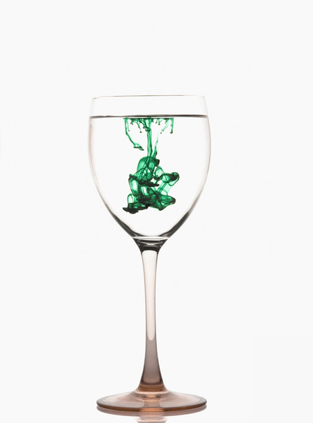 Green color streaks with water in a wine glass - Fotoğraf, Görsel