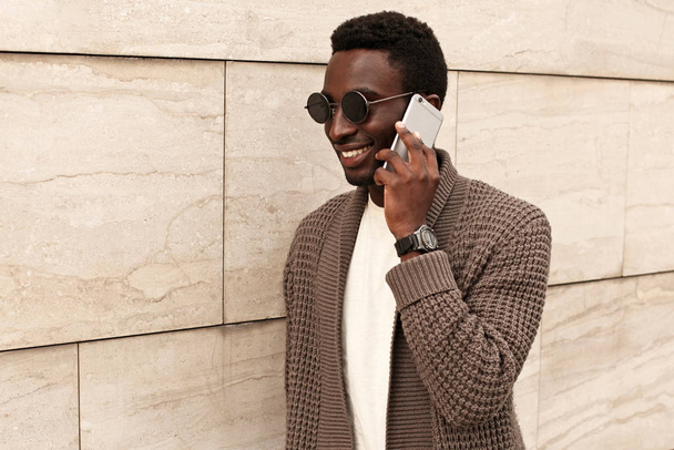 Portrait happy smiling african man calling on smartphone wearing - Fotó, kép