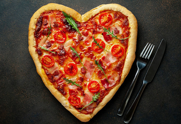 Heart shaped pizza with cutlery on granite background. Valentines day. - Foto, imagen