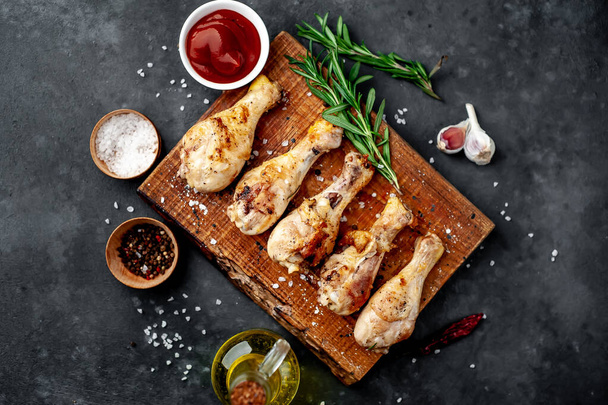 Jambes de poulet rôties avec saucisse barbecue et épices sur planche de bois
. - Photo, image
