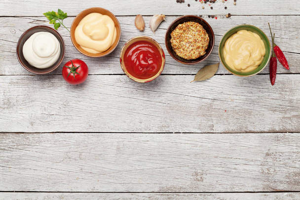 Set of various sauces. Popular sauces in bowls - ketchup, mustard, mayonnaise. Top view with copy space. Flat lay - 写真・画像