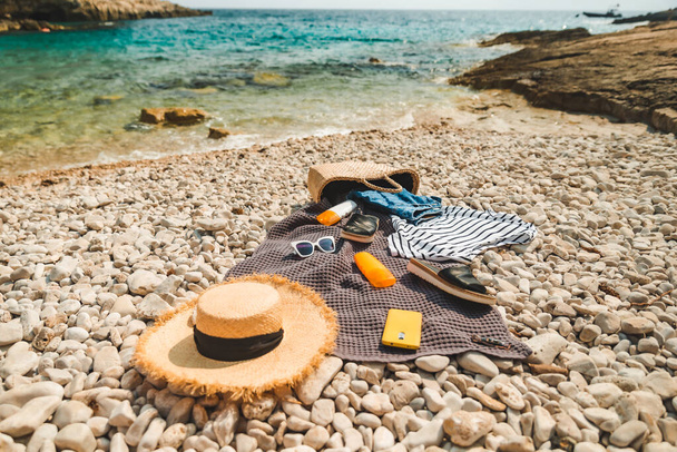 overhead view of beach stuff blanket with sun protection cream straw hat with bag - Photo, Image