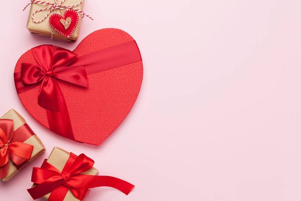 Tarjeta de felicitación de San Valentín con varias cajas de regalo sobre fondo rosa con espacio para sus saludos. Vista superior plano laico
 - Foto, imagen