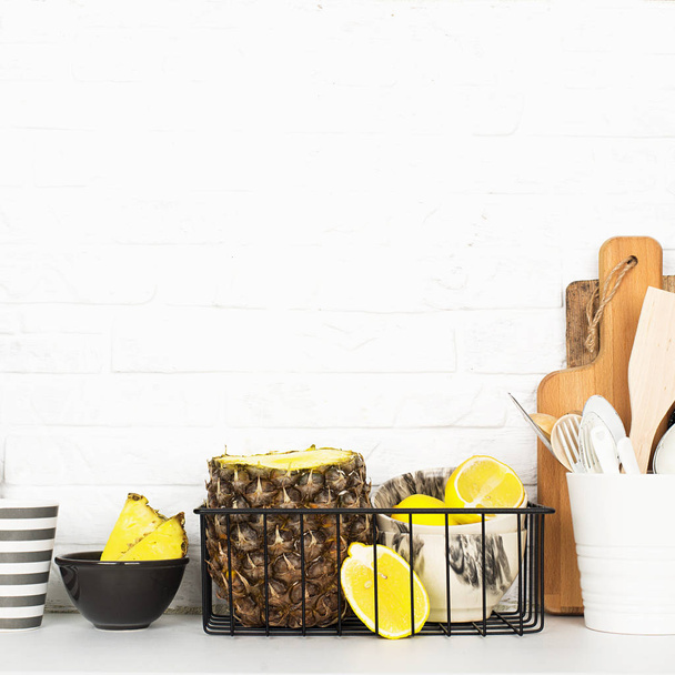 Kitchen shelf lifestyle white background with fresh lemons, pineapple, kitchen tools, appliances, chopping boards, storage baskets. Eco-friendly life. Home style, minimalism, healthy eating - Fotoğraf, Görsel