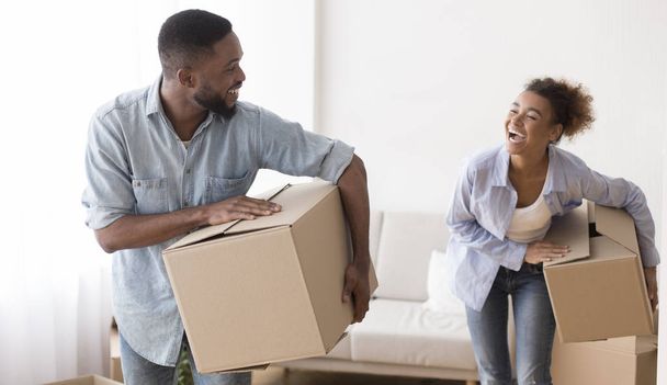 Joyeux couple afro portant des boîtes de déménagement entrant dans une nouvelle maison
 - Photo, image