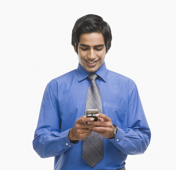 Businessman text messaging on a mobile phone - Fotoğraf, Görsel