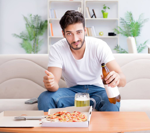 Man eating pizza having a takeaway at home relaxing resting - Fotoğraf, Görsel