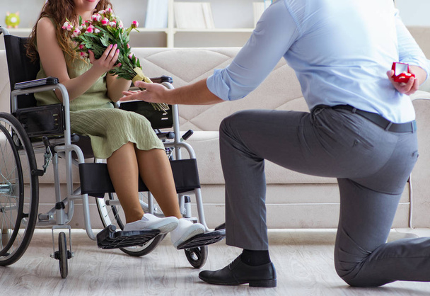 Man die huwelijksaanzoek doet aan gehandicapte vrouw in een rolstoel - Foto, afbeelding