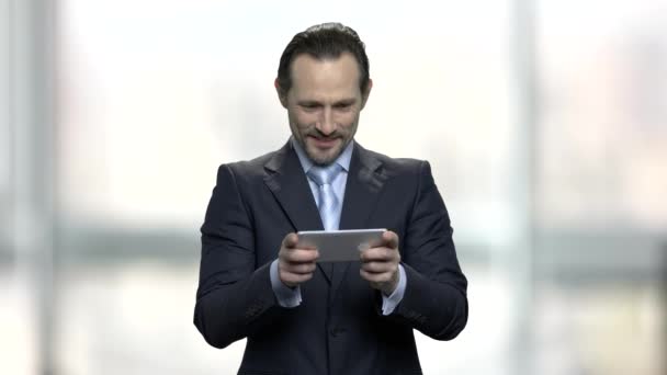 Businessman playing video game on smartphone. - Metraje, vídeo