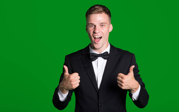 Business man in a jacket raised his thumbs up, isolated on a green background. - Foto, Imagen
