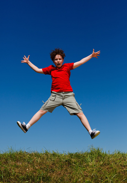 Boy jumping, running against blue sky - Foto, Imagen