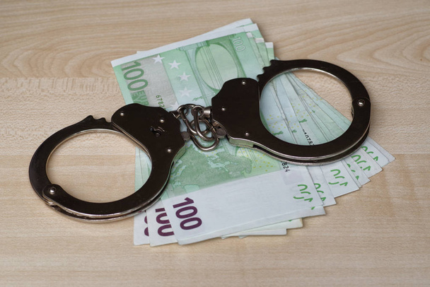 Theft of official money from the country budget, concept.The concept of corruption. Money and handcuffs. Punishment for a bribe prison. - Foto, afbeelding