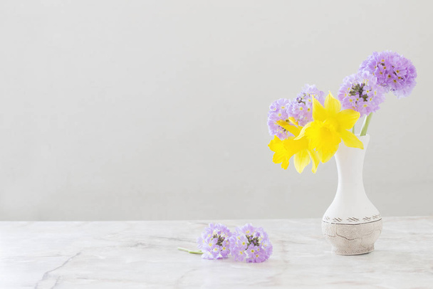 spring flowers in vase on marble table  - Foto, afbeelding