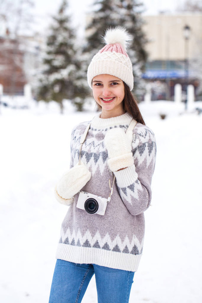 Young beautiful girl in a woolen sweater posing in the winter ou - Foto, afbeelding