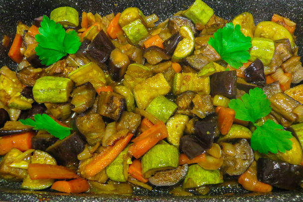 Stewed vegetables in a baked dish, decorated with greens. - Photo, Image