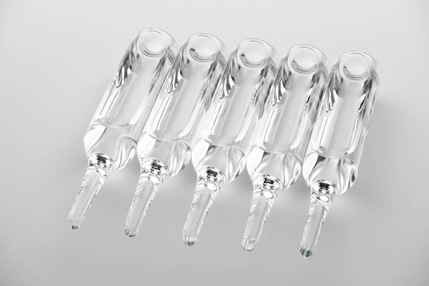 Ampoules. Transparent capsules with liquid on white background. Medicament for health care. Pharmaceutical industry. Pharmacy. - Photo, Image