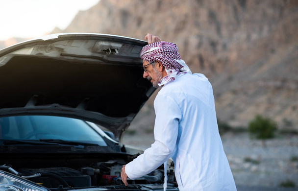 アラブ人男屋外で自分の車を固定 - 写真・画像
