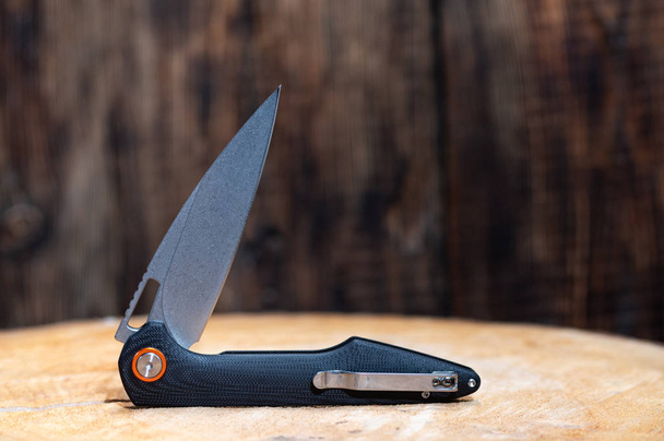 The knife is in a semi-folded position. Curved knife. - Photo, Image
