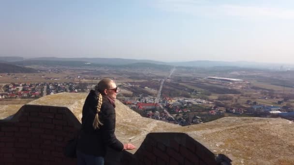 Vonzó női utazó néz körül völgyben, közel a régi vár - Felvétel, videó