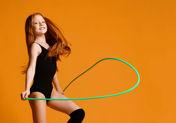 girl gymnast with red hair doing sports exercises jumping rope - Valokuva, kuva