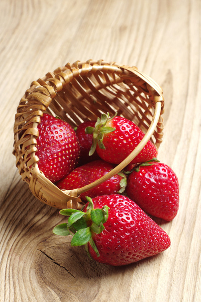 aardbeien in een mand en in de buurt van - Foto, afbeelding