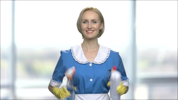 Smiling chambermaid holding bottles of detergents. - Footage, Video
