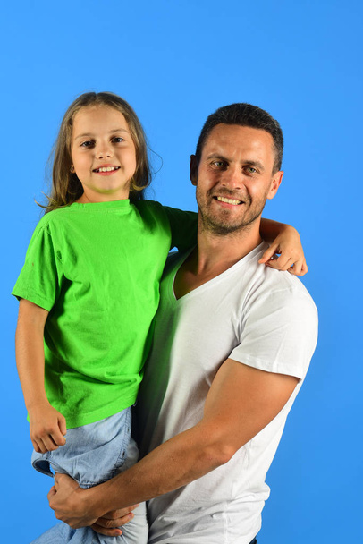 Schoolgirl sits on dads arms and smiles. Girl and man - 写真・画像