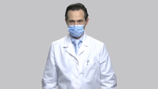 Serious mature doctor puts on stethoscope. - Video