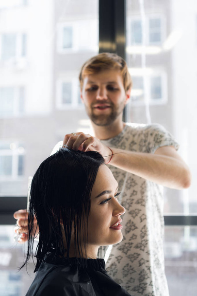 Hairdresser working in hair salon cutting womans hair - Photo, Image