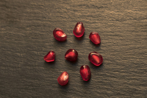Pomegranate seeds on isolated black background. - Φωτογραφία, εικόνα