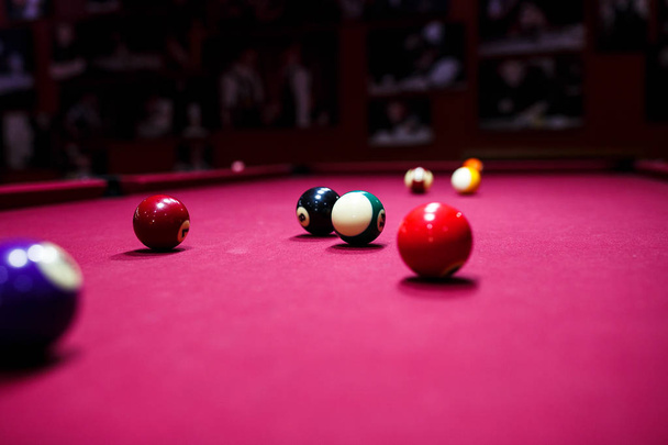 Boy plays billiard or pool in club. Young Kid learns to play snooker. Boy with billiard cue strikes the ball on table. Active Leisure, sport, hobby concept - Photo, image