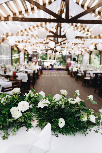 Modern wedding venue decorated with flowers and lights for a stylish boho wedding, vertical - Photo, Image