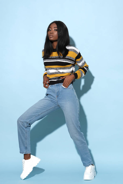 Fashion model in strike a pose wearing nice striped, colorful sweater. - Photo, Image