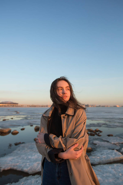 Portret van een mooie jonge vrouw. Fotoshoot serie bij rivier in de winter.  - Foto, afbeelding