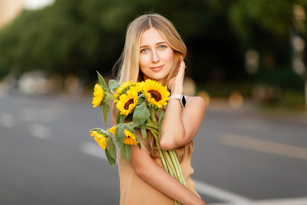 Portrait of beautiful woman with sunflowers - Foto, afbeelding