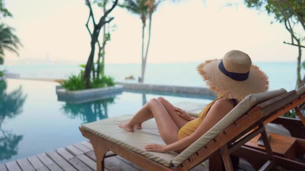 πλάνα της όμορφης Ασιάτισσας χαλαρώνοντας στην πισίνα του ξενοδοχείου - Πλάνα, βίντεο