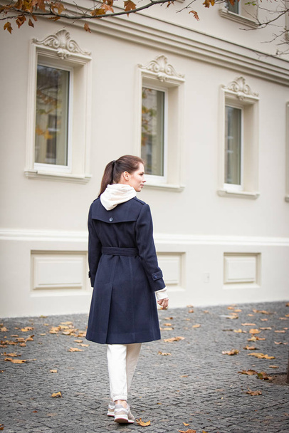 Beautiful brunette girl in a blue coat posing outdoors. - Foto, Bild