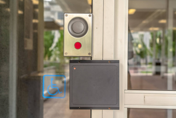 Egy modern épület üvegajtaja biztonsági kártyaolvasóval és mozgássérült táblával - Fotó, kép