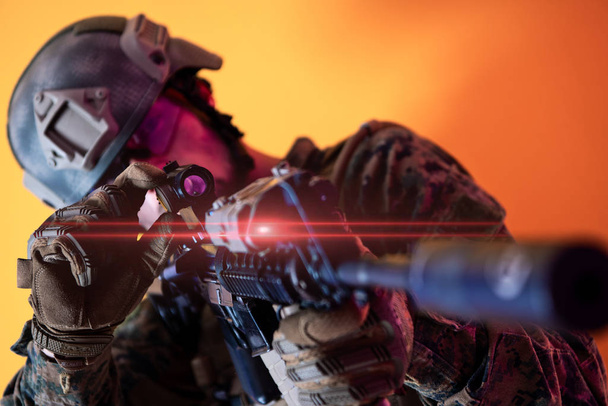 soldier in action aiming laseer sight optics yellow background - Φωτογραφία, εικόνα