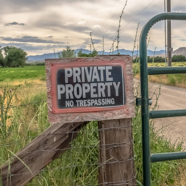 Square frame No Trespassing sign on the wire fence and green metal gate of private property - Photo, Image
