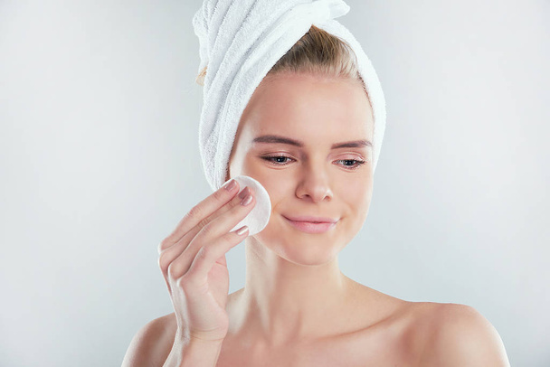 Menina fresca saudável removendo maquiagem de seu rosto com almofada de algodão. mulher com uma esponja wihte fundo algodão almofada problema pele
 - Foto, Imagem