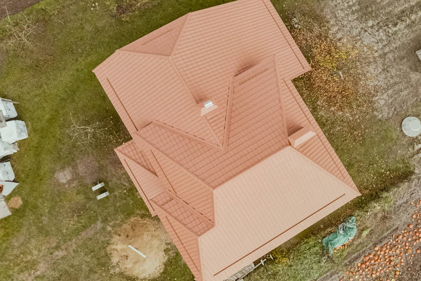 Dom z pomarańczowym metalowym dachem. Dach i metal falisty - Zdjęcie, obraz
