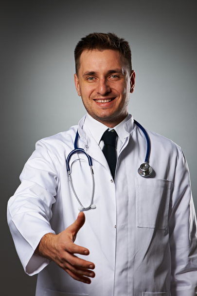 Arzt mit Stethoskop gibt Hand zum Händeschütteln - Foto, Bild