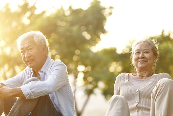asiatique senior homme et femme appréciant coucher de soleil dans parc
 - Photo, image