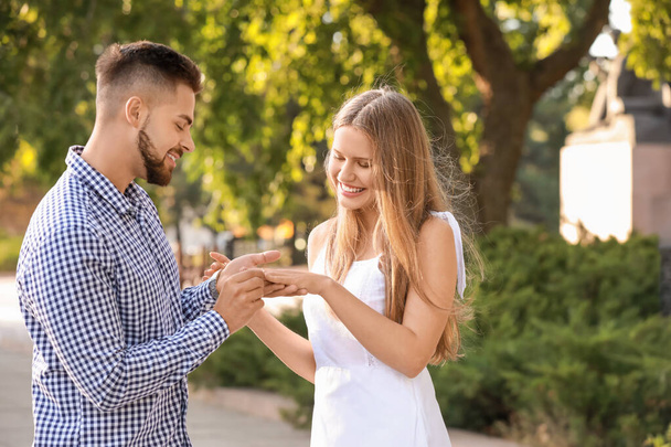 Young man putting ring on finger of his fiancee after marriage proposal - Photo, Image