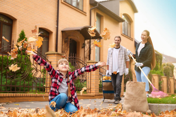 Family cleaning up autumn leaves outdoors - Photo, Image