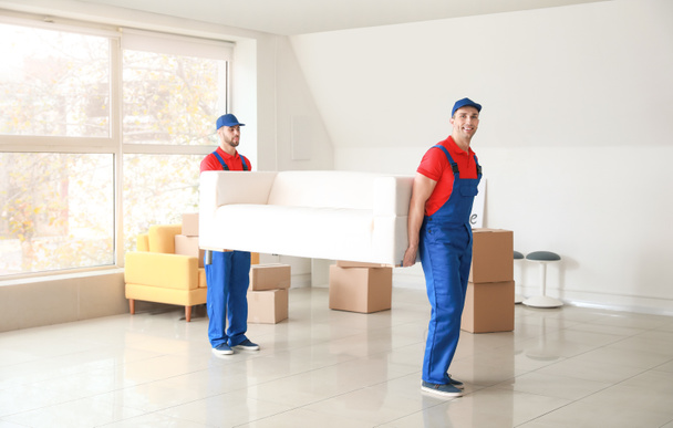 Cargadores que transportan muebles en el día en movimiento
 - Foto, imagen