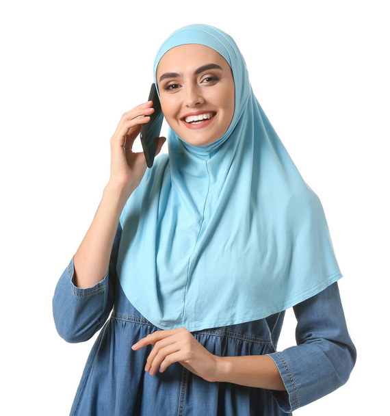 Beyaz arka planda telefonla konuşan güzel bir Arap kadını. - Fotoğraf, Görsel